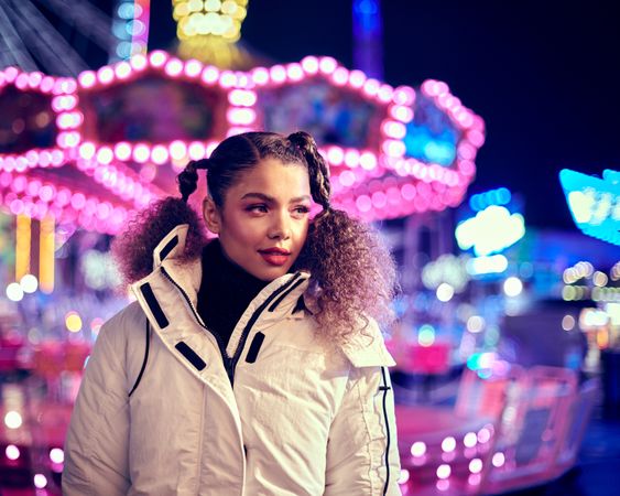 Young woman standing in front of carousel