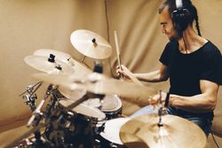 Man with headphones playing on drums