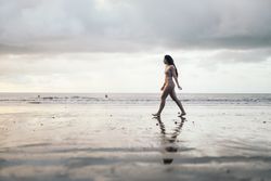 woman walking on the beach at sunset