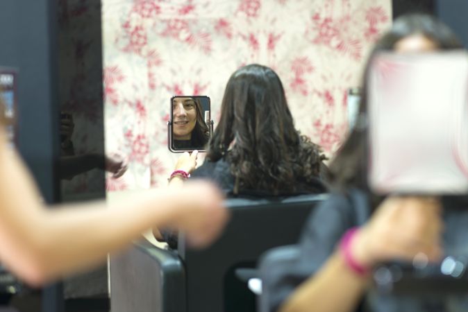 Hairdresser showing client new cut with mirror