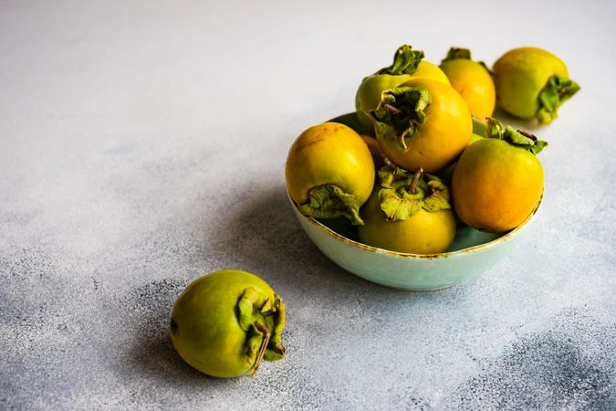 Bowl of persimmons on marble counter