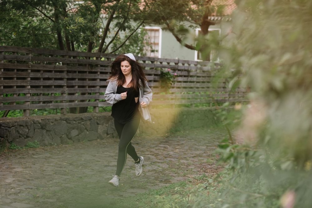 Positive woman running in park