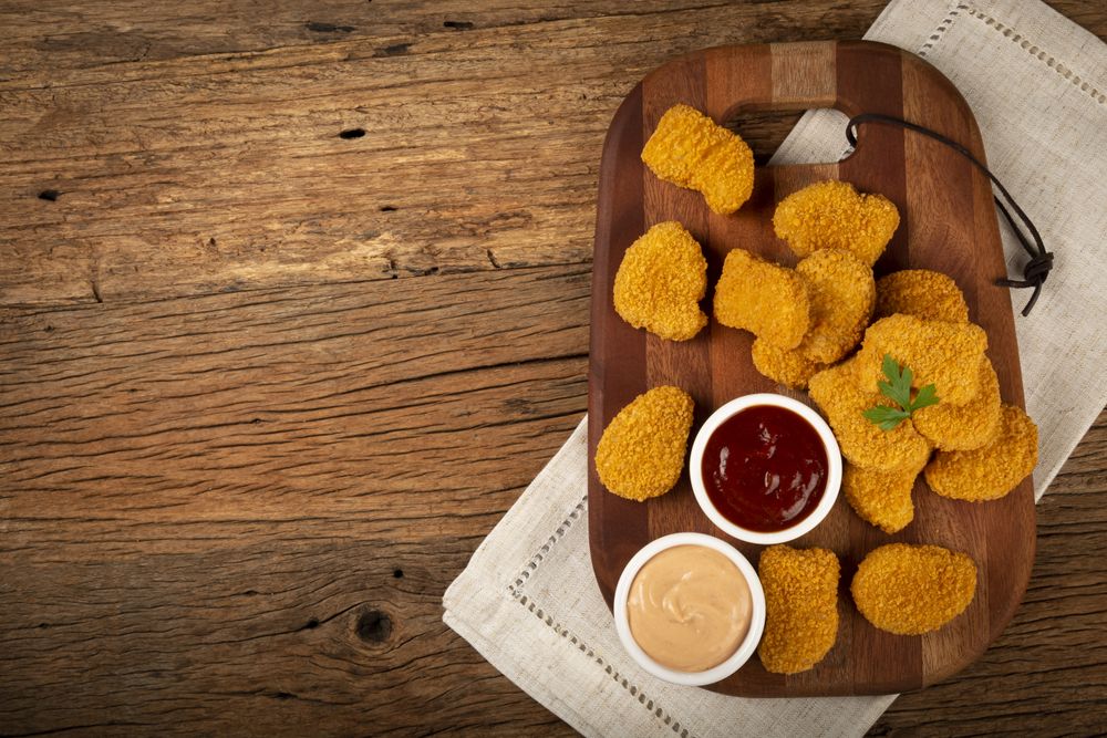 Fried chicken nuggets with ketchp and rose sauce.
