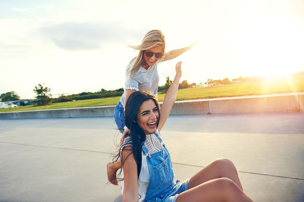 Two female friends playing on pedestrian street outside