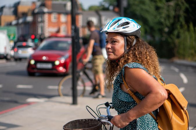 Happy Black woman looking around street on her bike in city streets
