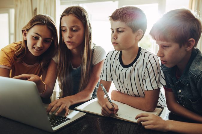 Group of kids learning together on a laptop computer