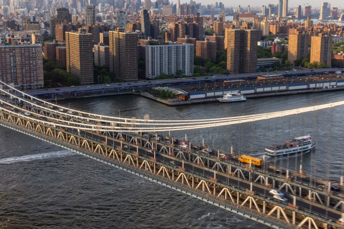 Aerial Cinematic Drone Scene Near a Bridge with Lower Manhattan Skyscrapers Cityscape. Beautiful Evening Sun Shining with Warm Sunset Light. Shot of a Suspension Bridge Architecture