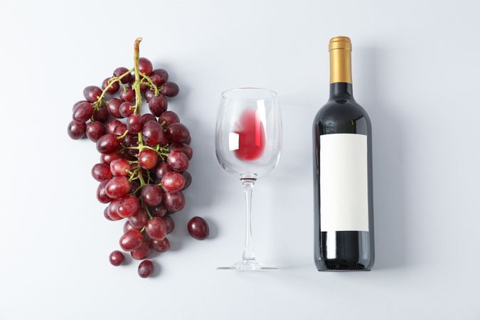 Flat lay composition with grapes, bottle and glass with wine, copy space