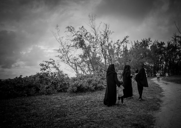 Three Middle Eastern women walking with children in a park