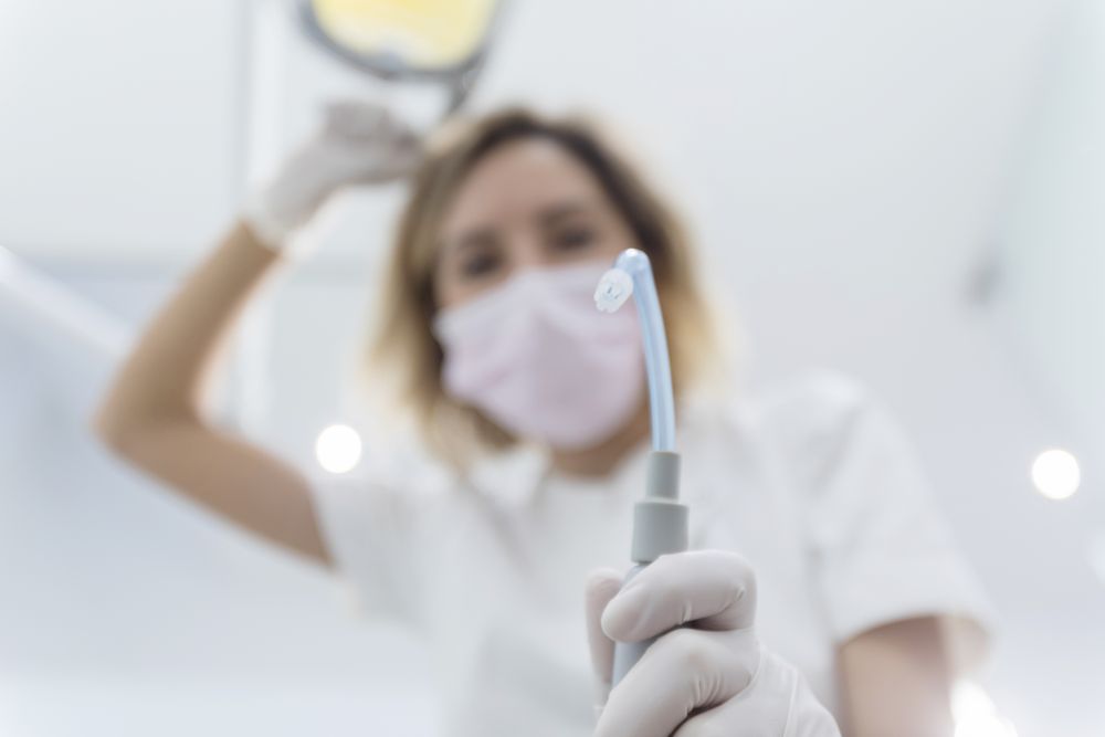 Female dentist leaned over patient in dentist's chair at clinic