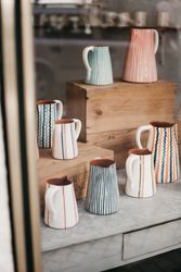 Ceramic jugs behind shop window