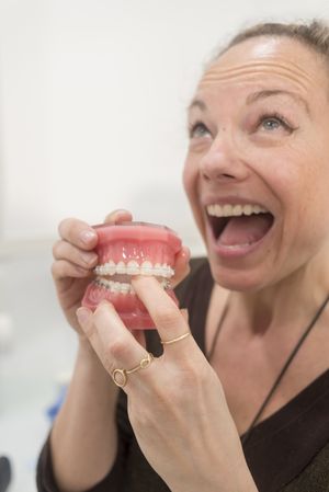 Humurous woman playing with jaws in dentist clinic
