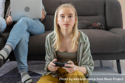 Young woman sitting on the floor controlling joystick playing video game 481rZb