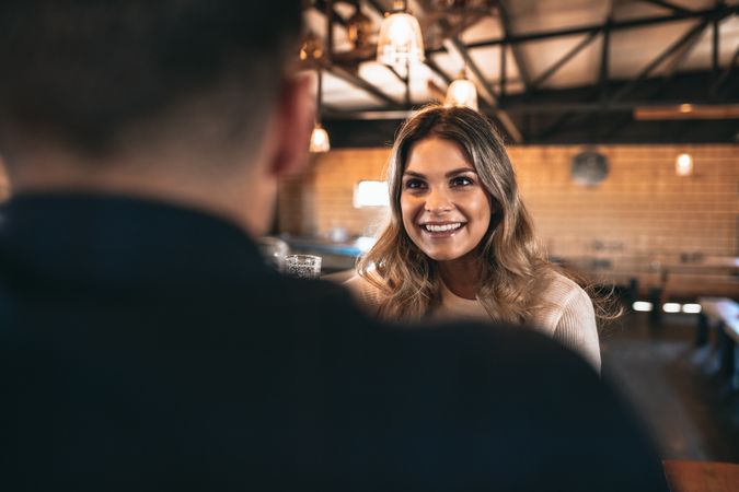 Beautiful young woman talking to boyfriend at brewery