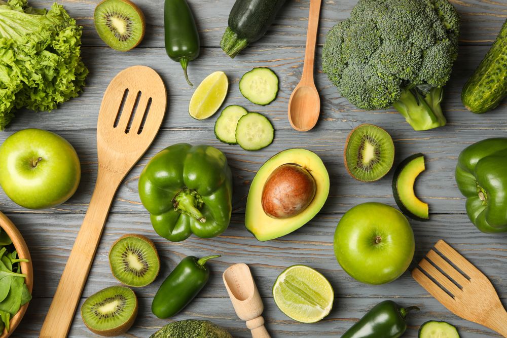 Cutlery, vegetables and fruits on wooden table