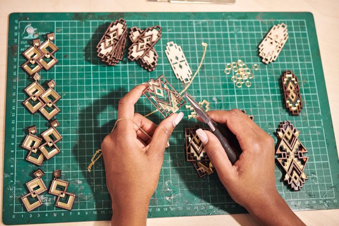 Manicured hands creating jewelry