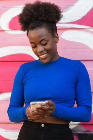 Content Black woman browsing smartphone in city