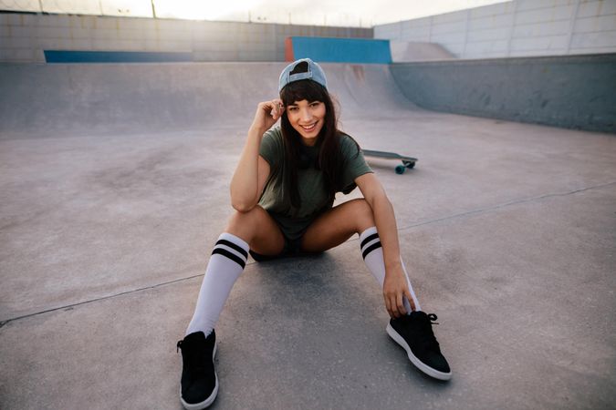 Portrait of attractive woman sitting relaxed at skate park