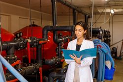 Safety inspector making notes in journal