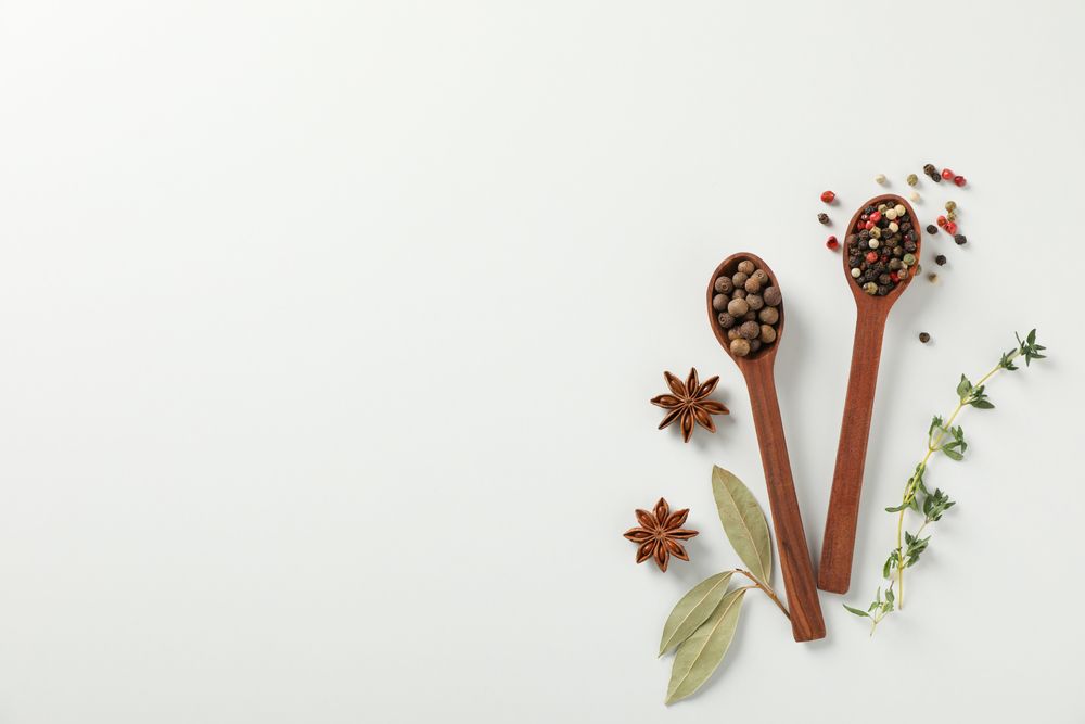 Top view of two wooden spoons full of pepper corns with copy space