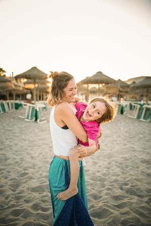 Woman with naughty boy on hands on beach
