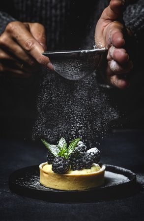 Hand holding a blackberry tartlet