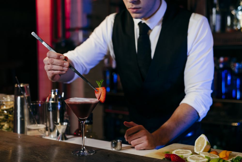 Barman working preparing drink in a glass