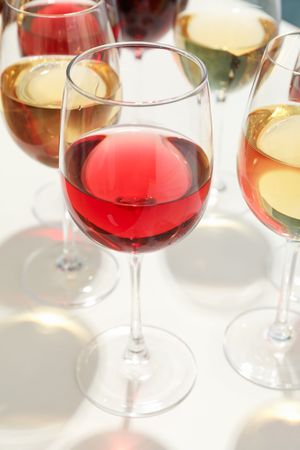 Glasses with different wine on blank background, closeup