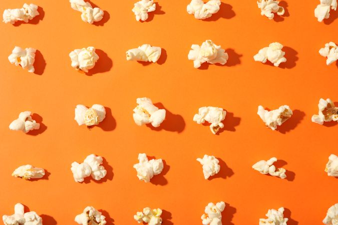 Flat lay composition with popcorn on orange background, closeup