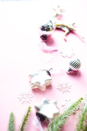 Christmas decorations scattered on pink background