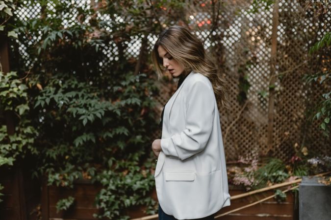 Woman standing on planter in garden