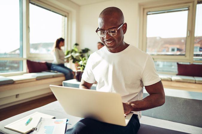 Content businessman working on his laptop in a bright office