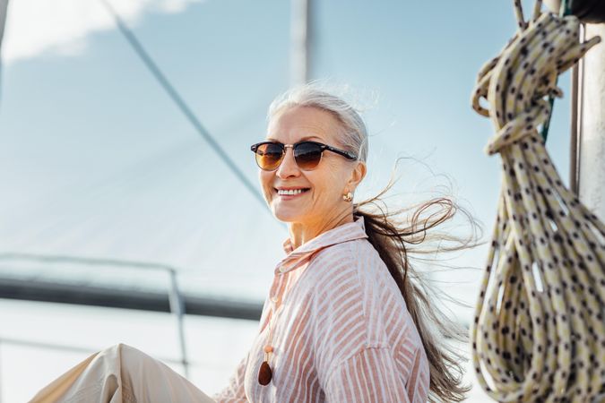 Stylish mature woman smiling on a yacht bow