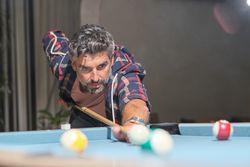 Concentrated bearded man playing pool