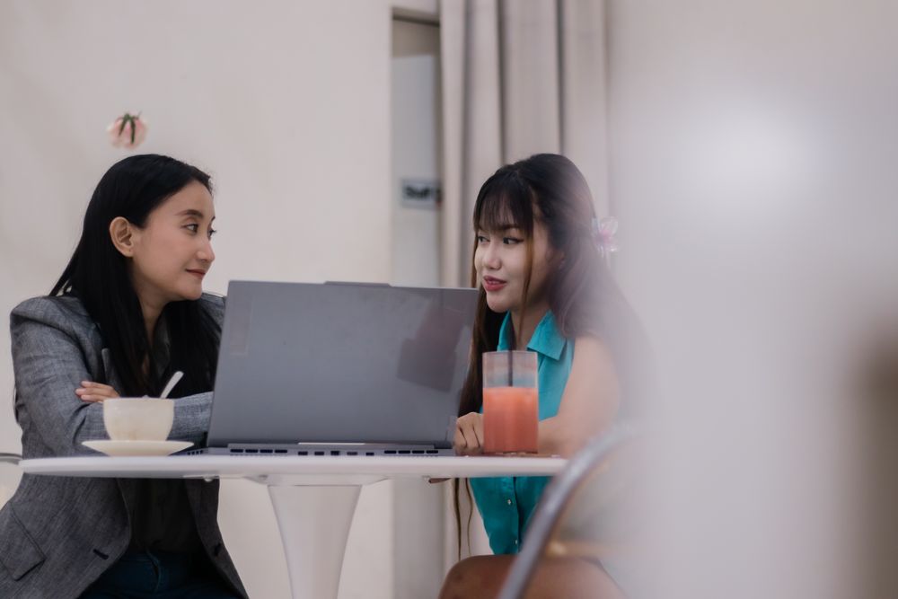 Engaging Discussion, Two colleagues work on a laptop in a modern