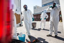 Men in PPEs and chemical facemask standing beside car outdoor during lockdown