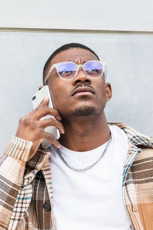 Stylish Black male using smartphone on street