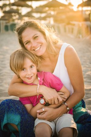Happy mother with playful son on beach