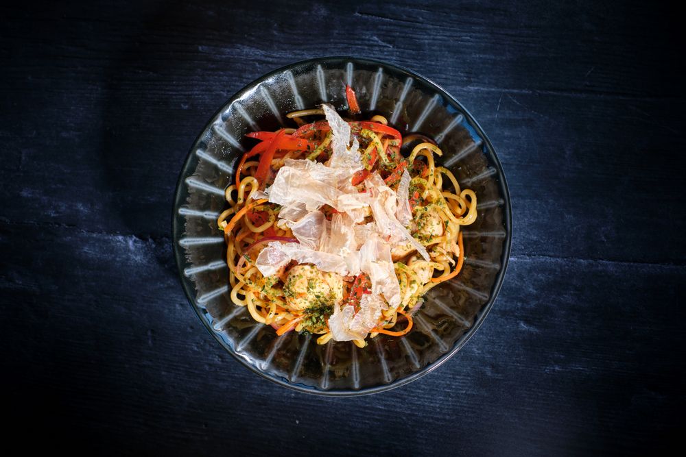 Appetizing noodles in bowl with crisps placed on table