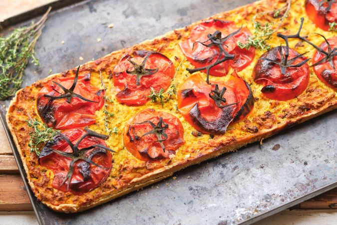Delicious flatbread with tomato slices and thyme sprigs