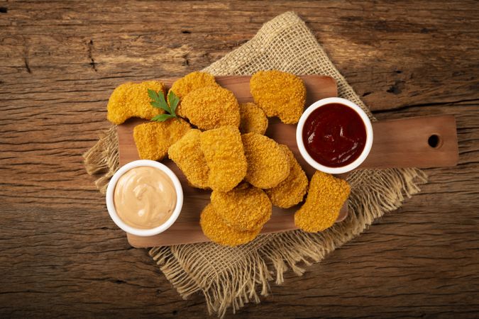 Fried chicken nuggets with ketchp and rose sauce.