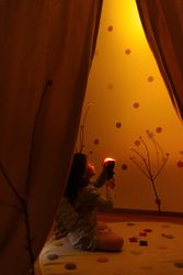 Anonymous girl with torchlight in bright decorated room