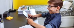 Happy preteen doing homework with a tablet