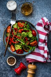 Healthy fresh salad with flax seeds served with striped napkin