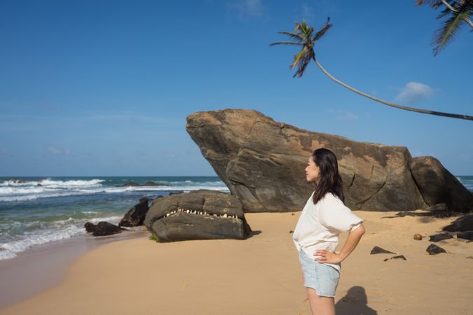 Woman in beachwear walking on sand barefoot