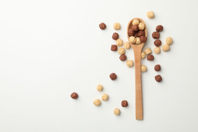 Spoon with corn balls on neutral background