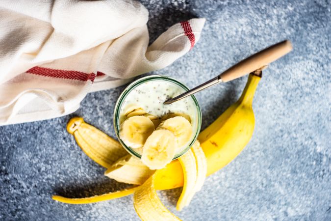 Top view of healthy breakfast with chia seeds and banana slices on counter with copy space