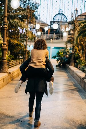 Man carrying happy girlfriend on back