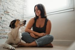 Woman with dog sitting on floor