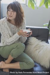 Happy female on cozy sofa with cup of tea, copy space 5zO7g4